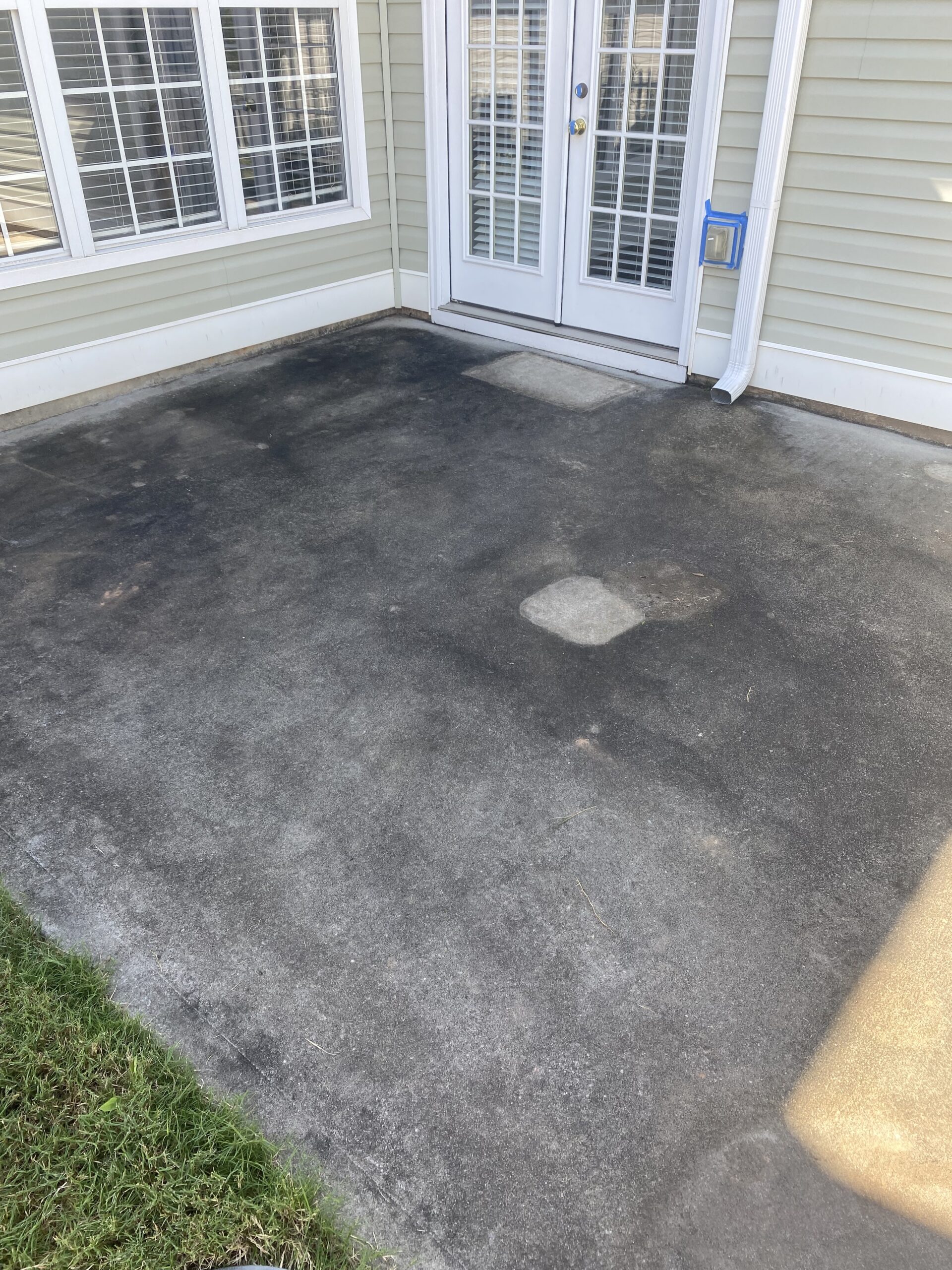 Concrete patio with French doors and patches