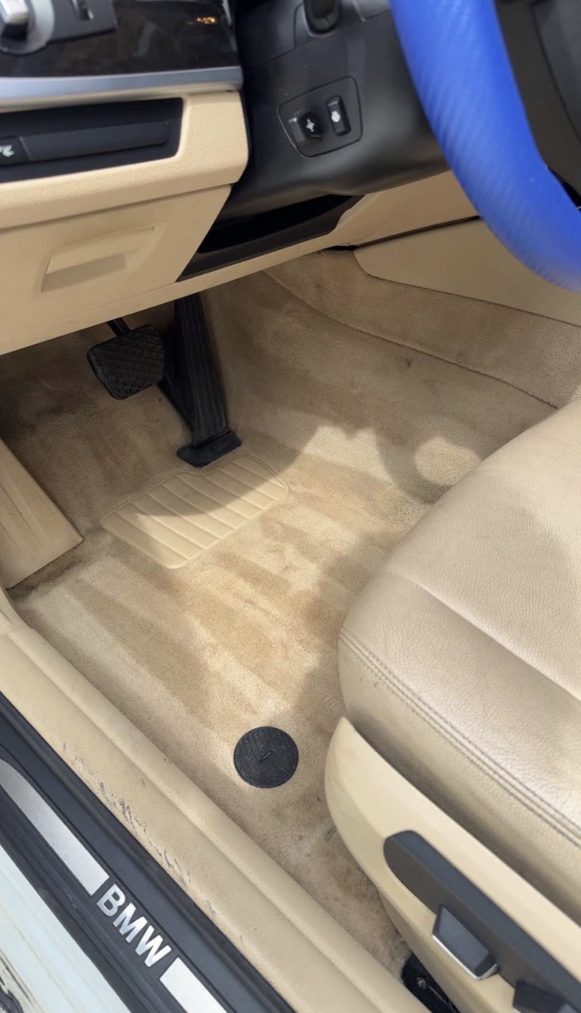 Beige BMW driver footwell, blue steering wheel cover