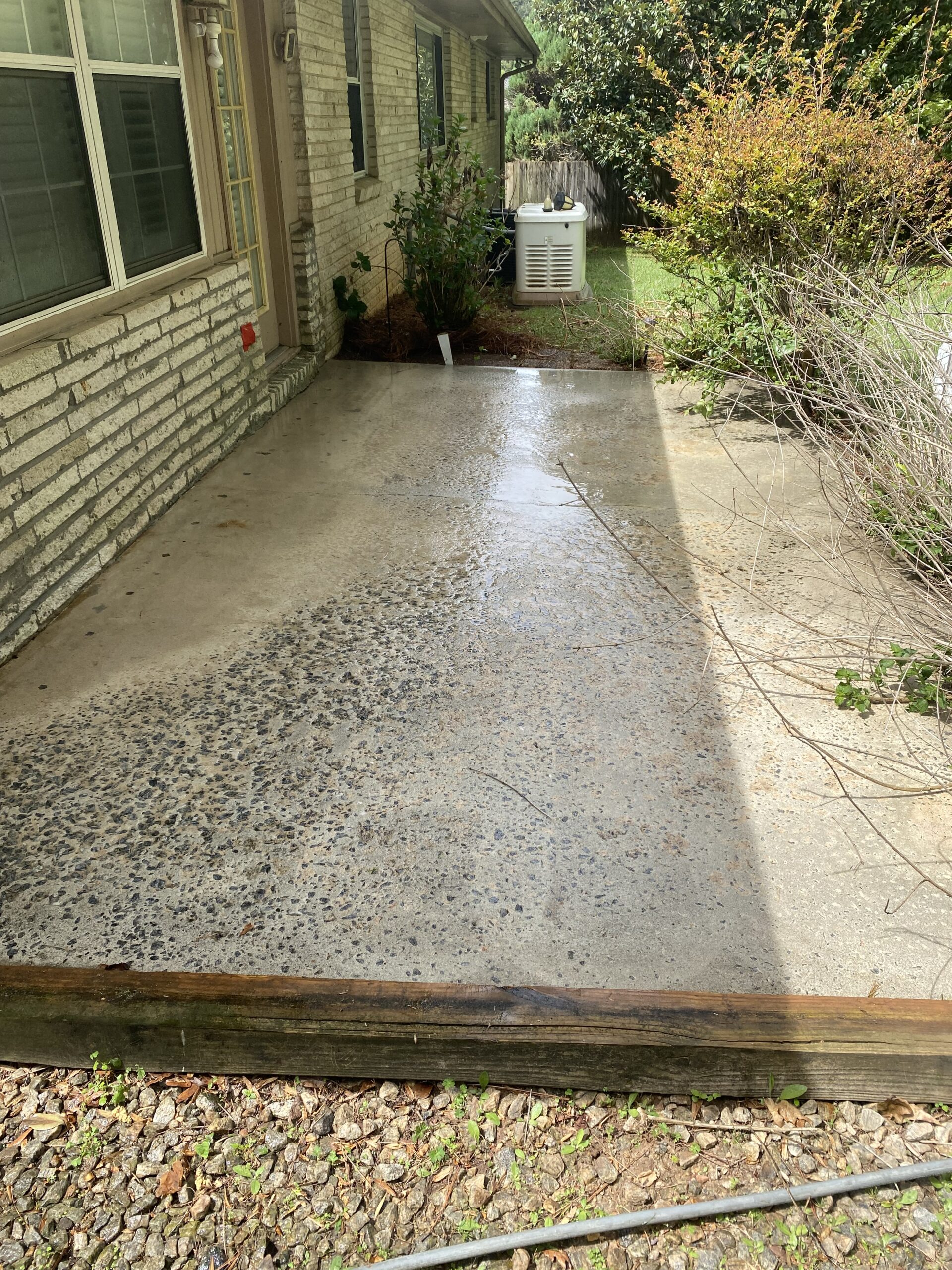 Wet concrete patio beside brick house