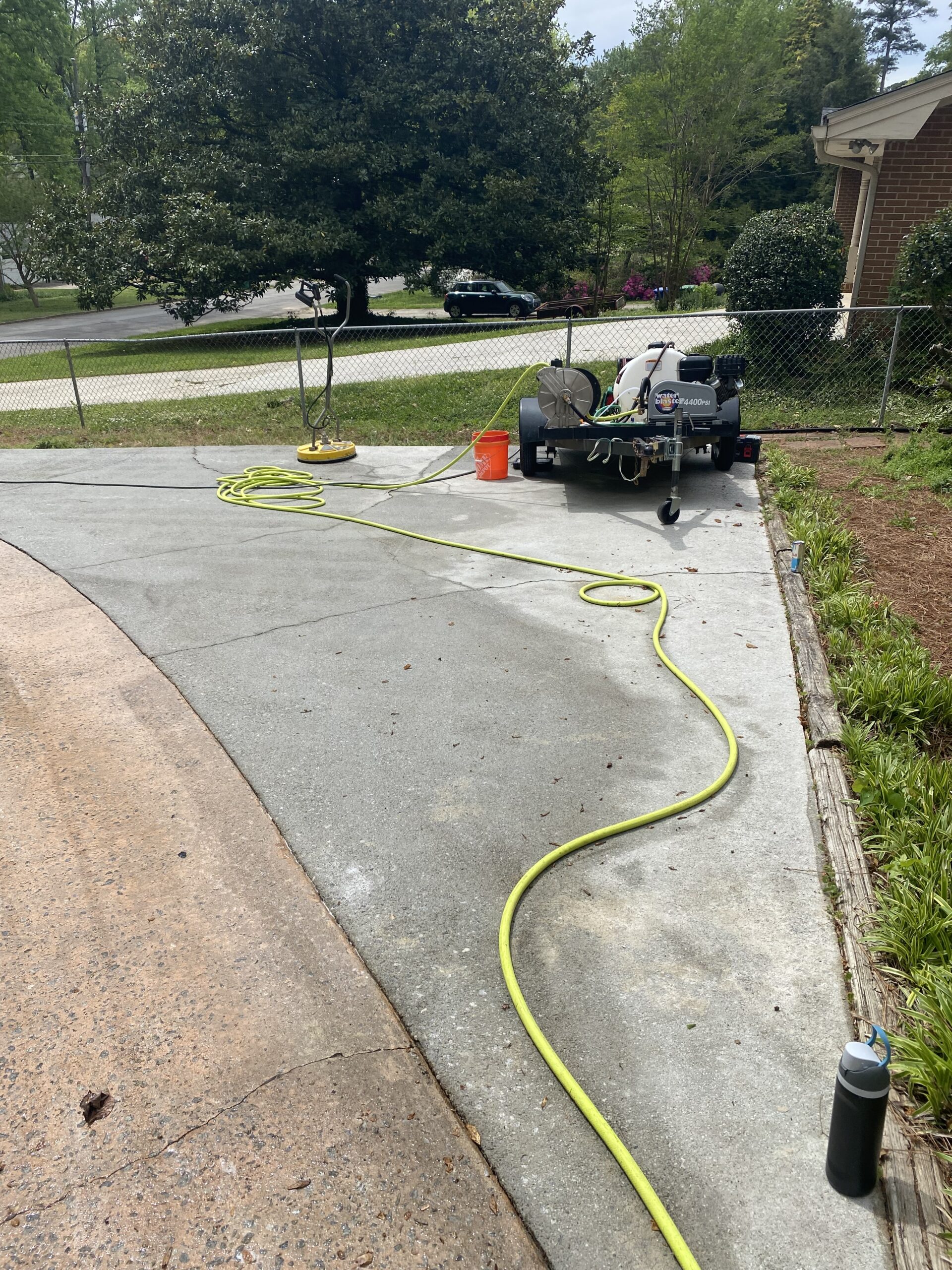 Pressure washer cleaning concrete driveway