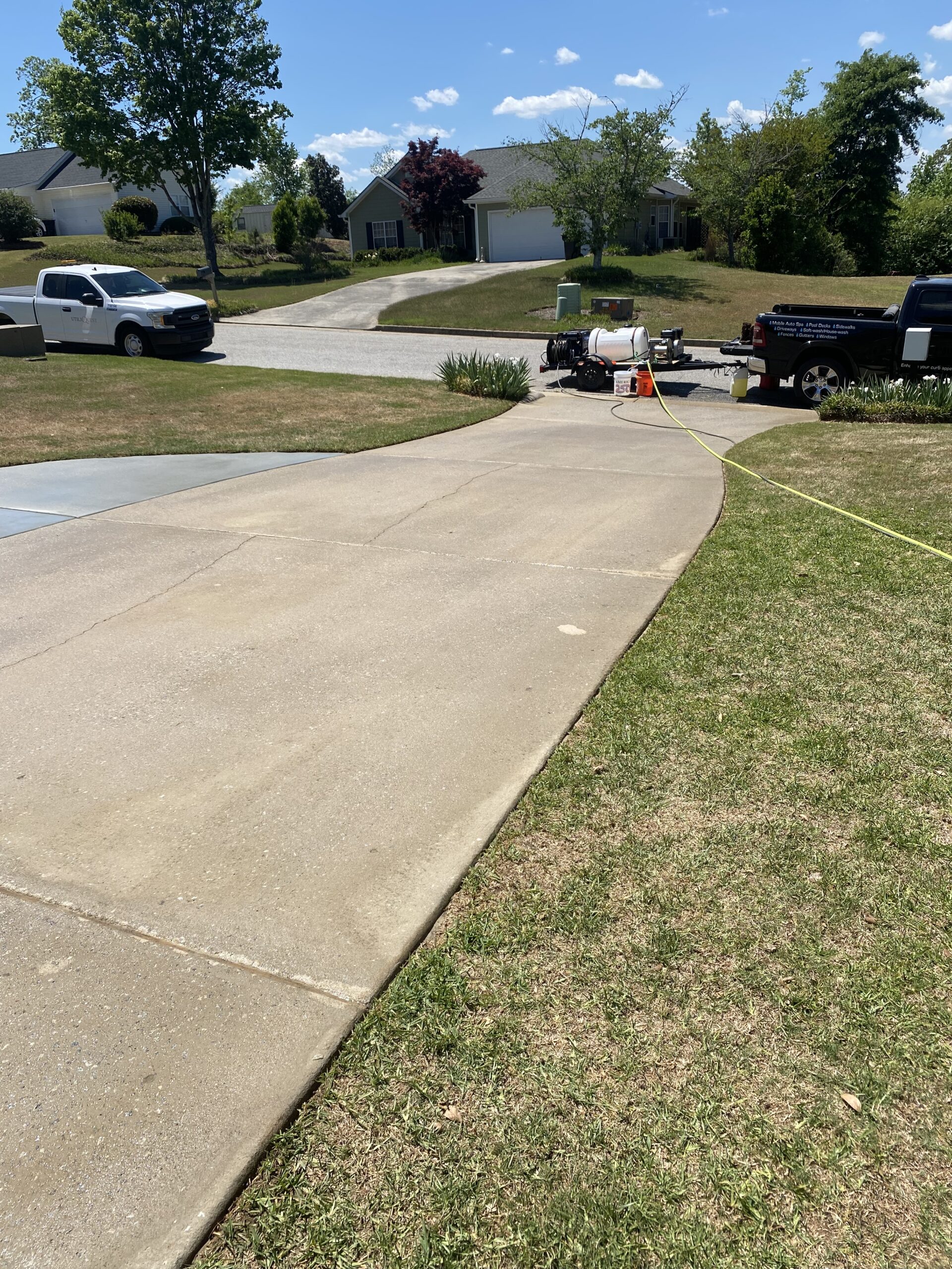 Concrete driveway with pressure-washing trucks
