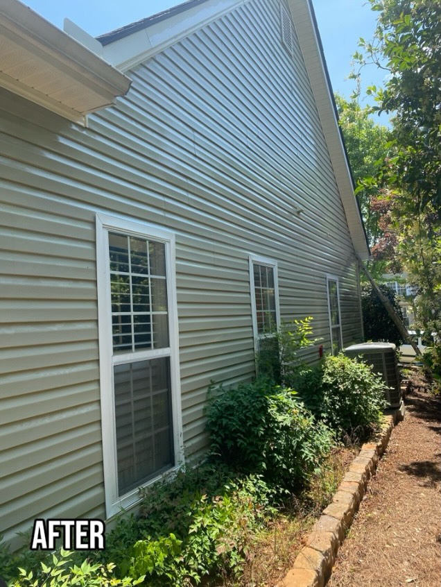 House side with clean vinyl siding and shrubs