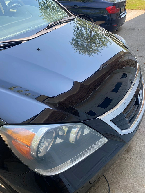 Black car hood and headlight reflection
