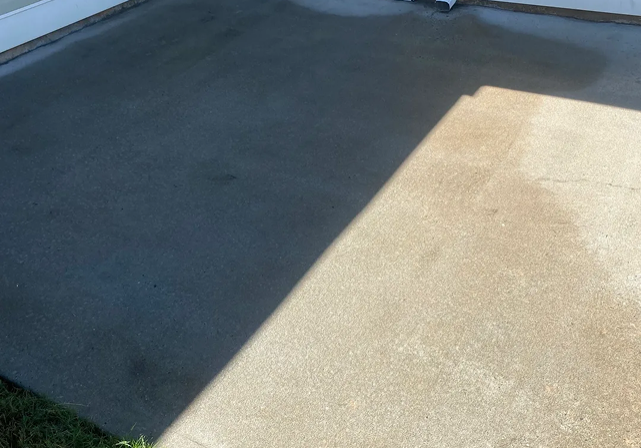 Sunlit concrete patio with shadow and downspout