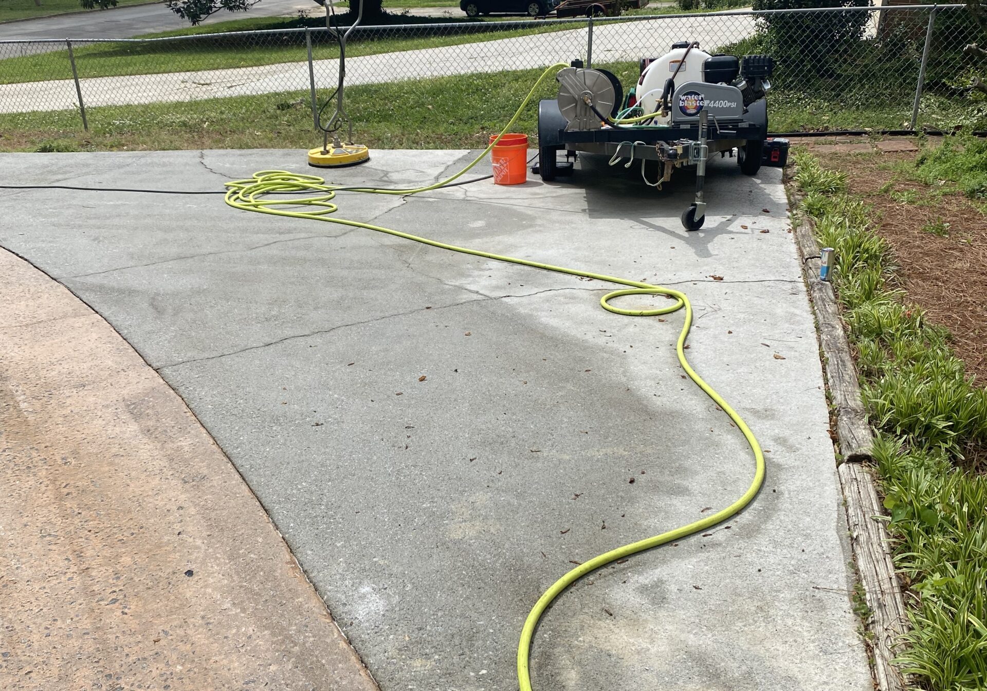Pressure washer and hose on concrete driveway