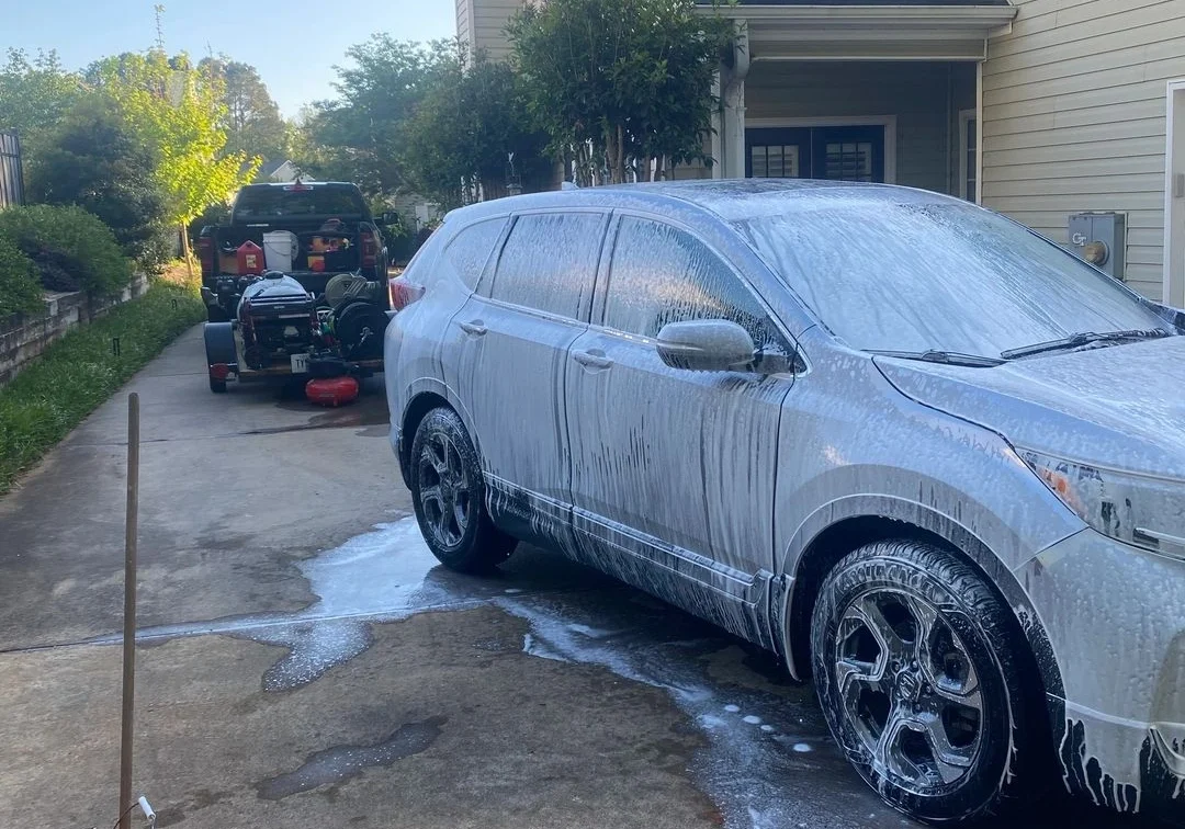 SUV covered in soap foam on driveway